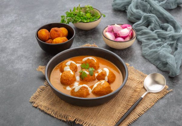 Cheese ball dipped in creamy gravy  and served in bowl